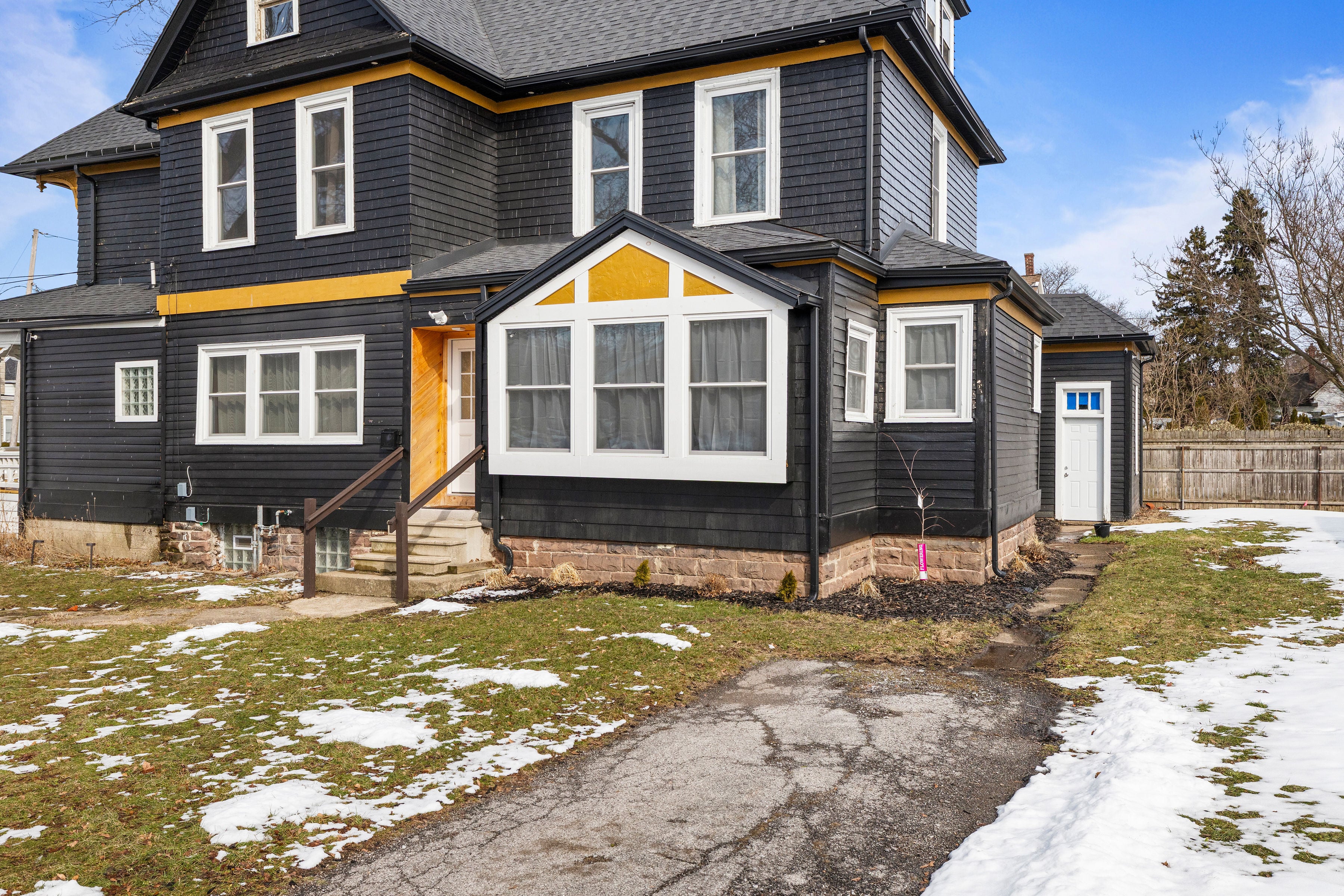 Our North Tonawanda Victorian home, with charcoal siding, bay windows, and golden trim