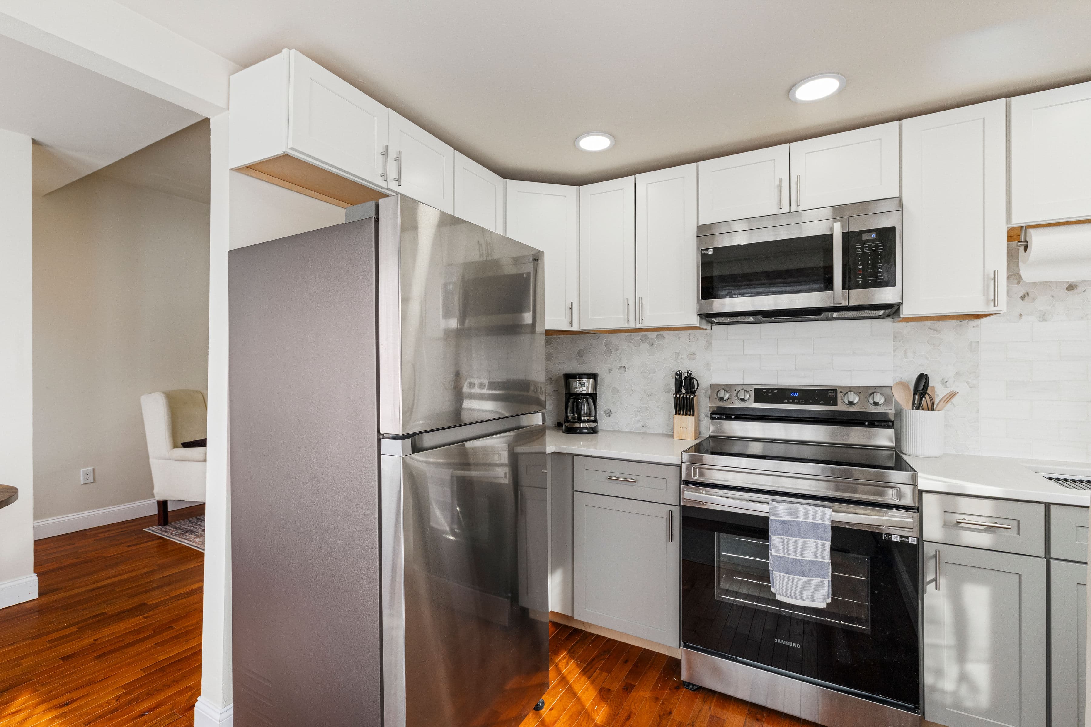 Full kitchen with stainless steel appliances and marble backsplash
